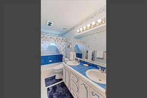 Bathroom featuring double vanity, light tile patterned floors, and shower / bath combo