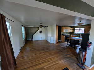 Living room featuring dark wood-style floors and ceiling fan