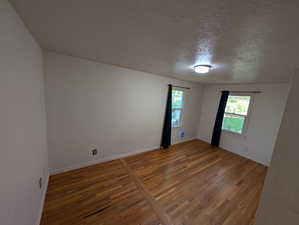 Empty room featuring hardwood / wood-style floors and a textured ceiling