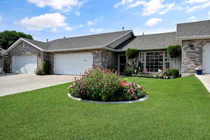Ranch-style house with roof with shingles, brick siding, and an attached garage