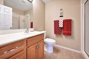 Full bath featuring vanity, a shower stall, and light tile patterned floors