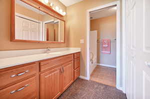 Full bath featuring vanity, a closet, and dark tile patterned flooring