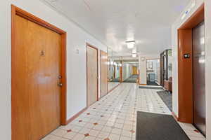 Hall featuring elevator and baseboards