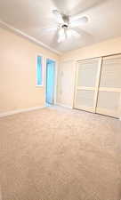 Unfurnished bedroom with a closet, carpet, and ceiling fan