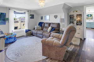 Living area with lofted ceiling, hardwood / wood-style floors, and a chandelier
