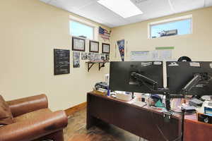 Office with a drop ceiling and baseboards