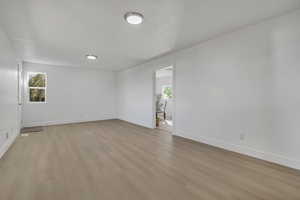 Unfurnished room with light wood-style floors and baseboards