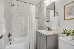 Bathroom with shower / bath combo with shower curtain and vanity