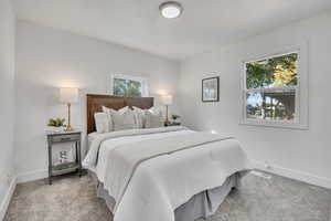 Bedroom with baseboards and light carpet