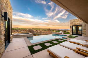 View of pool with a patio area and a pool with connected hot tub