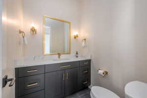 Half bathroom with vanity and dark tile patterned floors