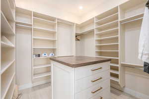 Walk in closet with light wood-style floors