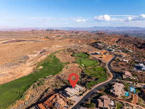 Aerial overview of property's location featuring a mountain backdrop and a golf club
