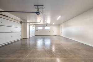 Garage with baseboards and a garage door opener