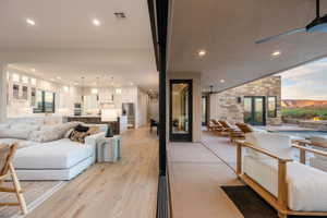 Living room with light wood-type flooring and recessed lighting