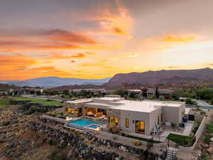 Rear view of house featuring a patio, a mountain view, and stucco siding