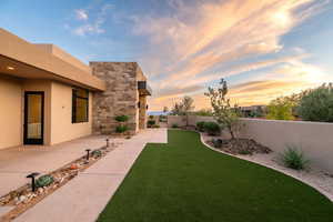 Yard at dusk featuring a fenced backyard and a patio