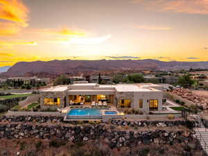 Rear view of property featuring a patio area, an infinity pool, a mountain view, an in-ground hot tub, and outdoor lounge area
