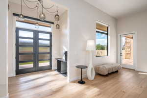 Foyer entrance with light wood-style flooring, plenty of natural light, and french doors