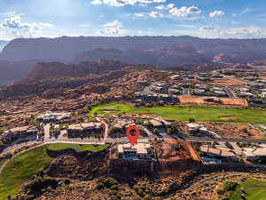 Aerial view of property and surrounding area with nearby suburban area and a mountain backdrop