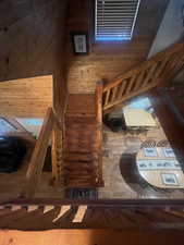 Staircase featuring wooden walls, wood finished floors, and a high ceiling
