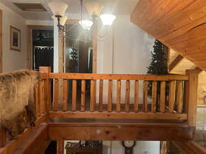 Stairway with wooden ceiling, a chandelier, and lofted ceiling
