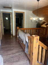 Bedroom featuring wood finished floors, a textured ceiling, and a chandelier