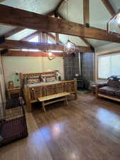 Bedroom with wood finished floors and a wood stove