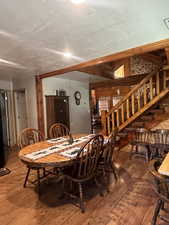 Dining area with stairs, wood finished floors, and a textured ceiling