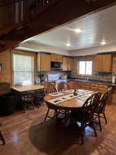 Dining space with light wood-style flooring, a textured ceiling, and wood walls