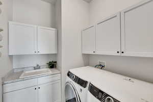 Laundry area featuring cabinet space and washing machine and clothes dryer