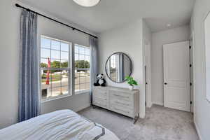 Bedroom featuring light carpet and baseboards