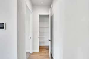 Corridor with baseboards and light wood-style floors