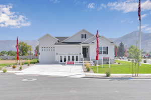 View of front of home with a mountain view, an attached garage, and concrete driveway