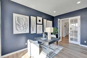Office area with french doors, light wood-style floors, and recessed lighting