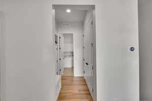 Corridor featuring light wood finished floors and recessed lighting