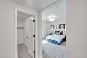 Bedroom featuring light colored carpet and a textured ceiling