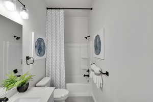 Full bathroom with shower / tub combo, vanity, and light tile patterned floors