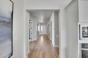 Hallway featuring light wood finished floors and recessed lighting
