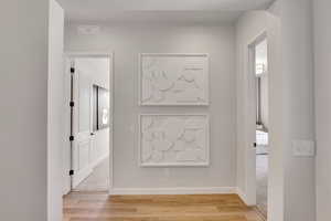 Corridor with baseboards and light wood finished floors