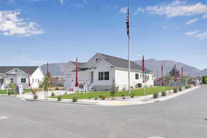 View of front of house with a mountain view, a front yard, and a residential view