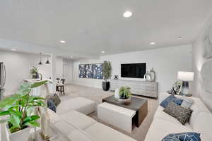 Carpeted living room with recessed lighting and a textured ceiling