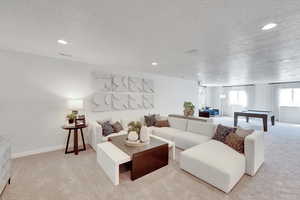 Living area with light carpet, billiards, a textured ceiling, and recessed lighting