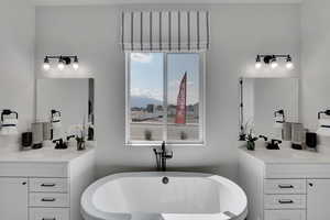 Full bath with two vanities, a soaking tub, and a mountain view