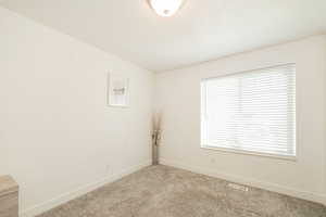 Empty room with carpet floors and baseboards