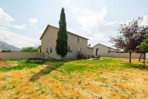 Back of house with a fenced backyard and a mountain view