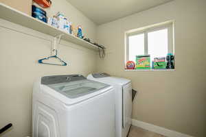 Washroom featuring independent washer and dryer and light tile patterned floors