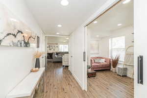 Hall with plenty of natural light, light wood-type flooring, and recessed lighting