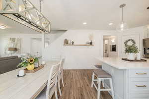 Dining area featuring dark wood finished floors, a textured ceiling, and recessed lighting