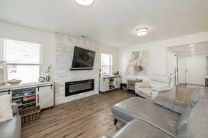 Living area with wood finished floors, a fireplace, and a textured ceiling